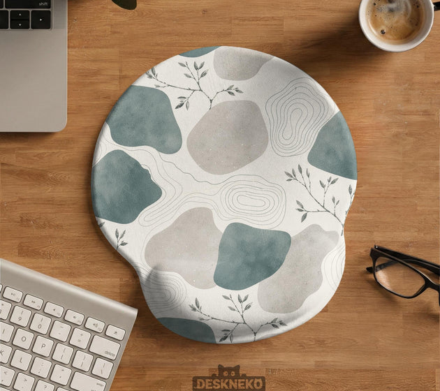 Sage green ergonomic mousepad and keyboard wrist rest with abstract shapes, soft gray details, cream space, topographic contour lines, and leafy branch accents.