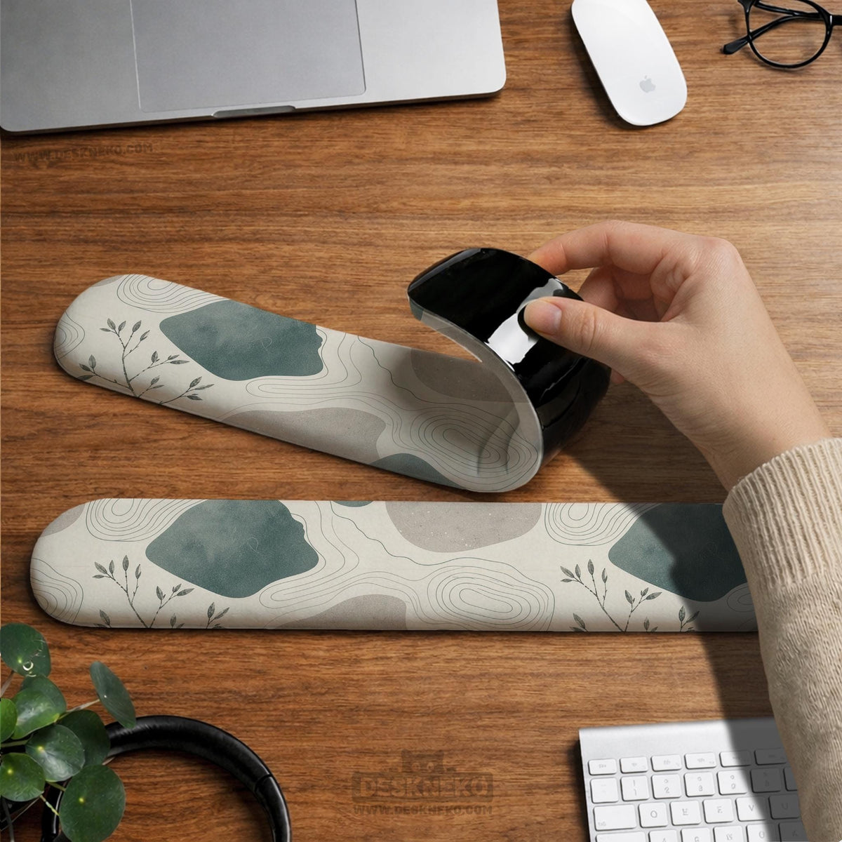 Sage green ergonomic mousepad and keyboard wrist rest with abstract shapes, soft gray details, cream space, topographic contour lines, and leafy branch accents.