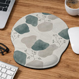 Sage green ergonomic mousepad and keyboard wrist rest with abstract shapes, soft gray details, cream space, topographic contour lines, and leafy branch accents.