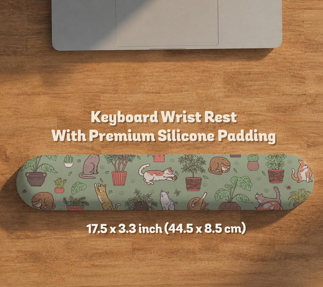 Sage green desk mat with a pattern of lounging cats, leafy plants, cactus pots, and earthy botanical details.