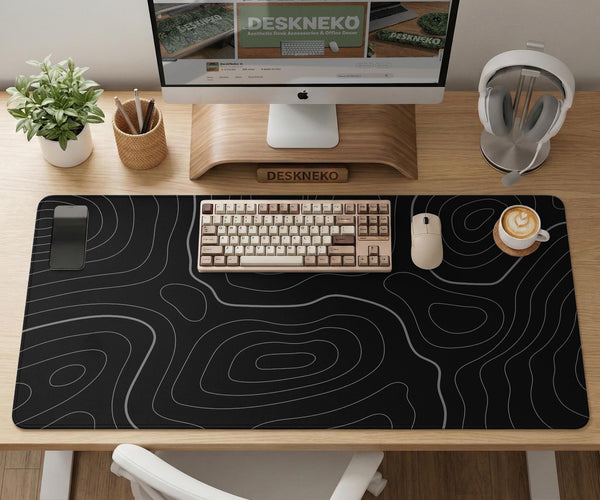 Black desk mat with a thin gray topographic contour line pattern.