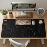 Black desk mat with a thin gray topographic contour line pattern.