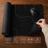 Black desk mat with a thin gray topographic contour line pattern.