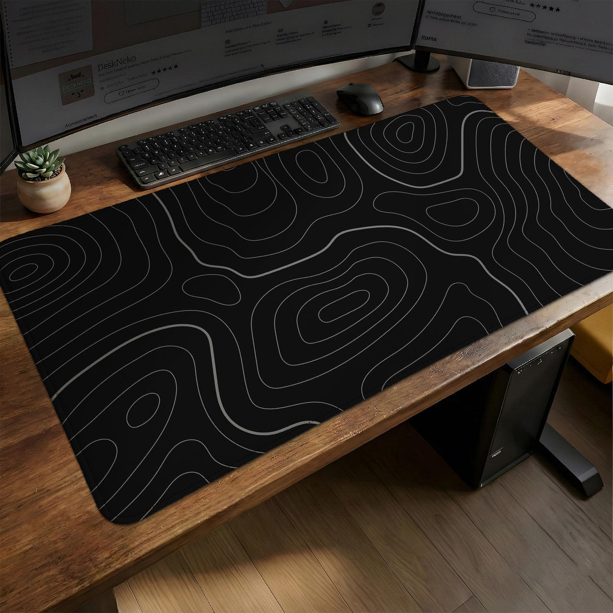 Black desk mat with a thin gray topographic contour line pattern.