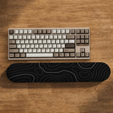 Black mousepad with a gray topographic contour line pattern shown with matching keyboard wrist rest options.