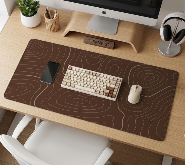 Brown desk mat with a repeating topographic contour line pattern in a neutral earth tone design.