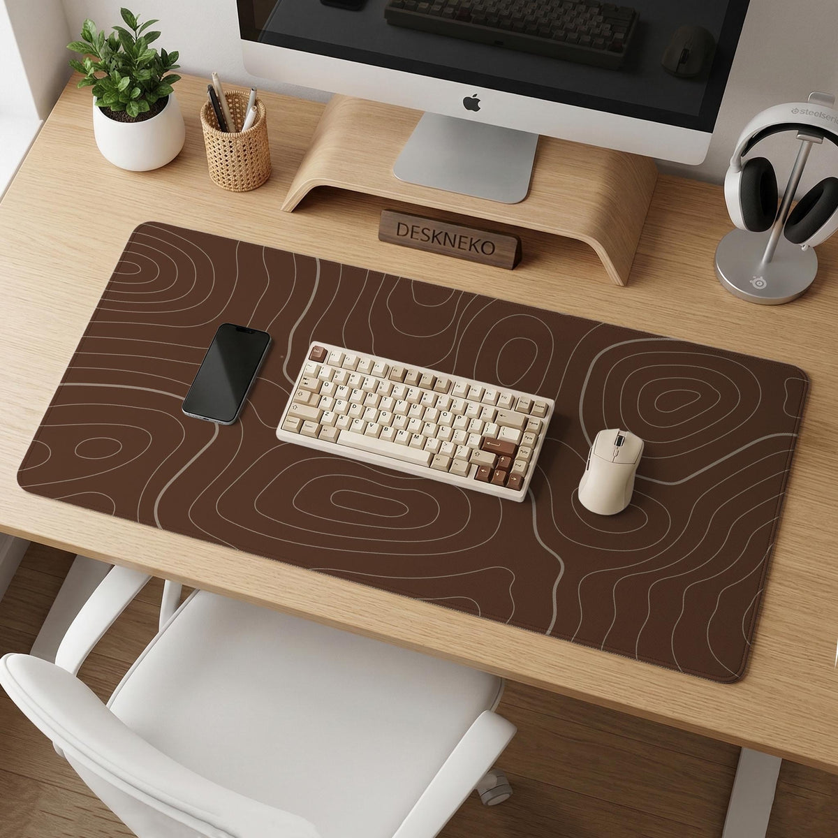 Brown desk mat with a repeating topographic contour line pattern in a neutral earth tone design.