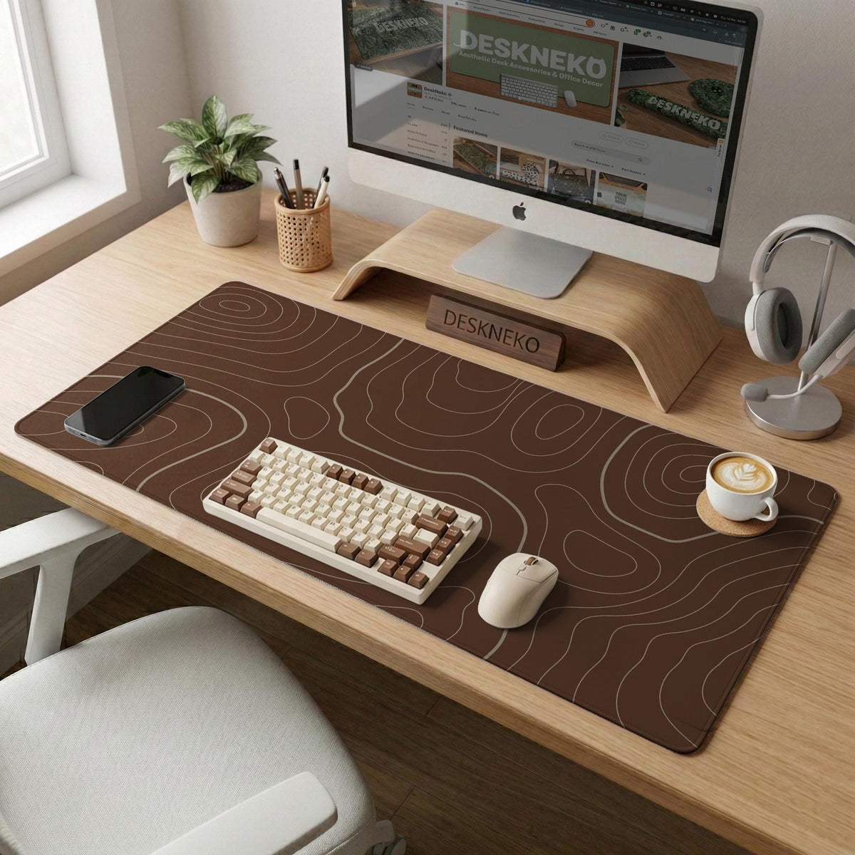 Brown desk mat with a repeating topographic contour line pattern in a neutral earth tone design.