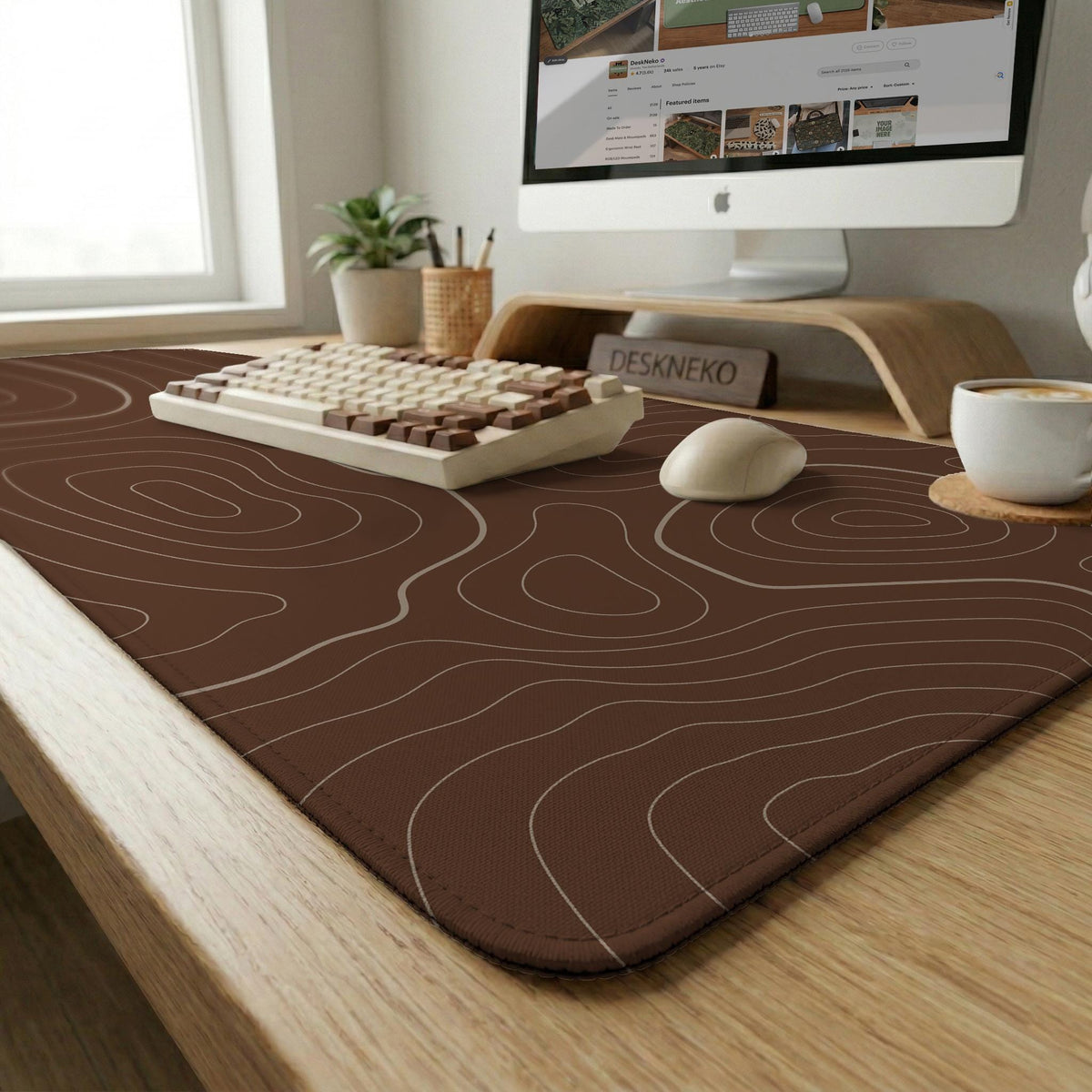 Brown desk mat with a repeating topographic contour line pattern in a neutral earth tone design.
