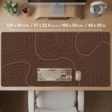 Brown desk mat with a repeating topographic contour line pattern in a neutral earth tone design.