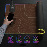 Brown desk mat with a repeating topographic contour line pattern in a neutral earth tone design.