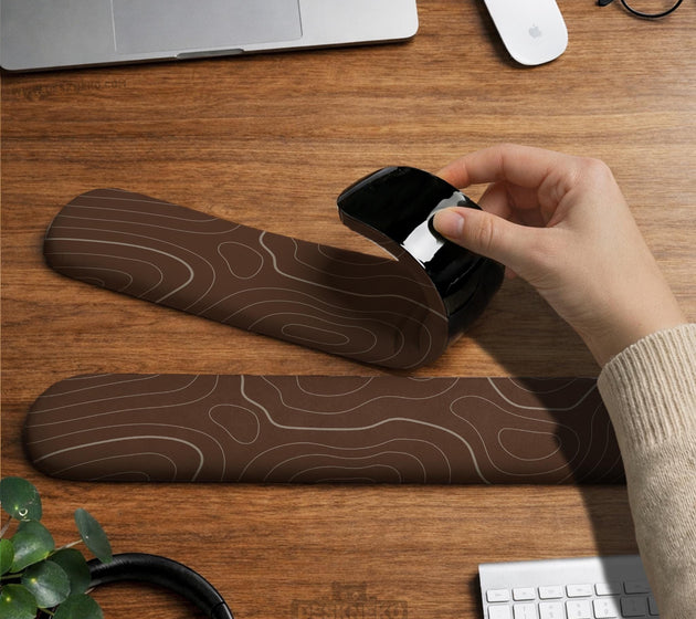 Brown mousepad and keyboard wrist rest with a topographic contour-line pattern.