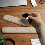 Beige mousepad and keyboard wrist rest with a topographic line pattern shown in a neutral desk setup.