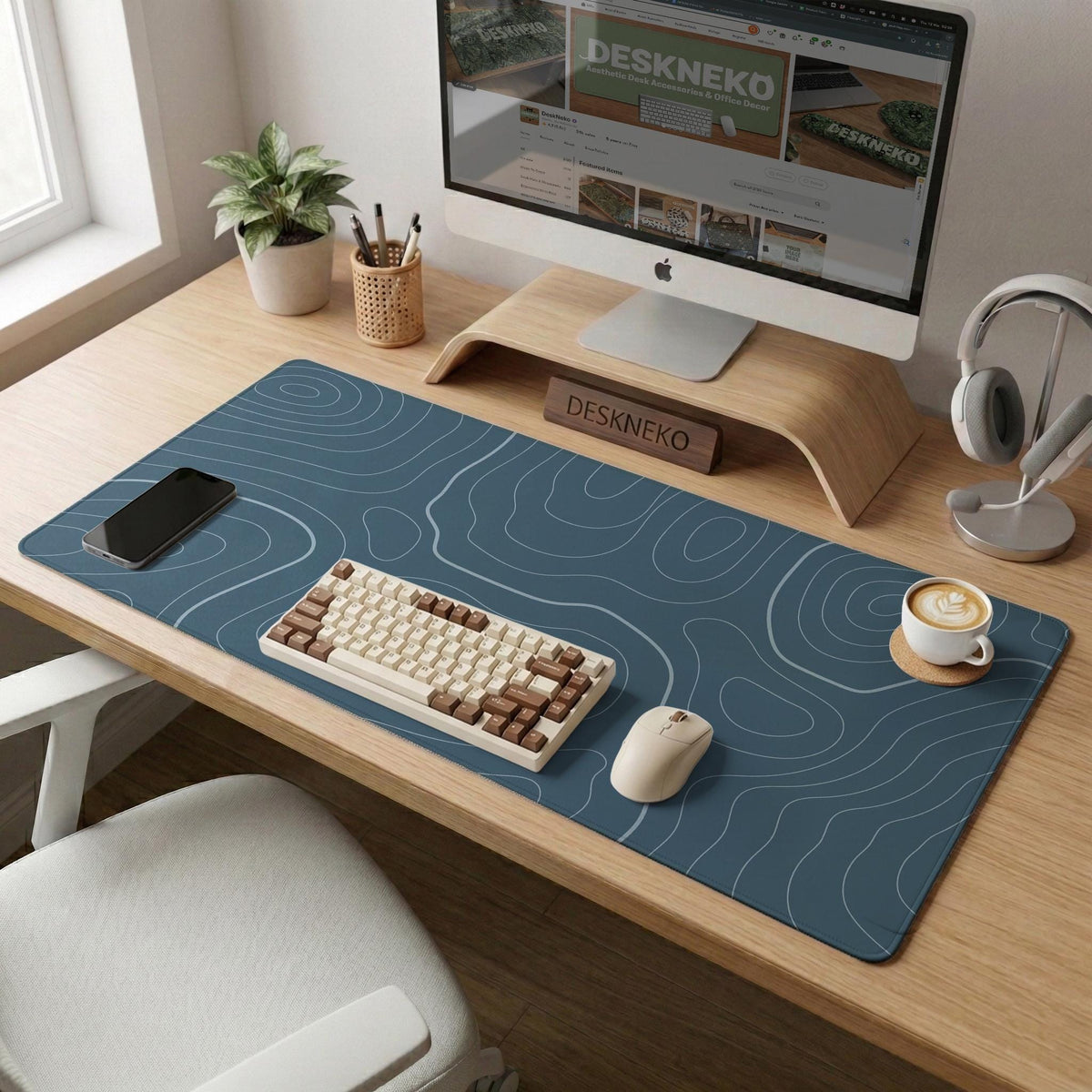 A slate blue desk mat with thin contour line map art on a light background.