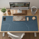 A slate blue desk mat with thin contour line map art on a light background.