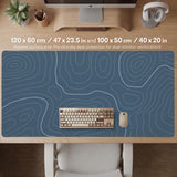 A slate blue desk mat with thin contour line map art on a light background.
