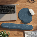 Muted blue desk mat with thin topographic line art pattern shown with matching mousepad and keyboard wrist rest options.
