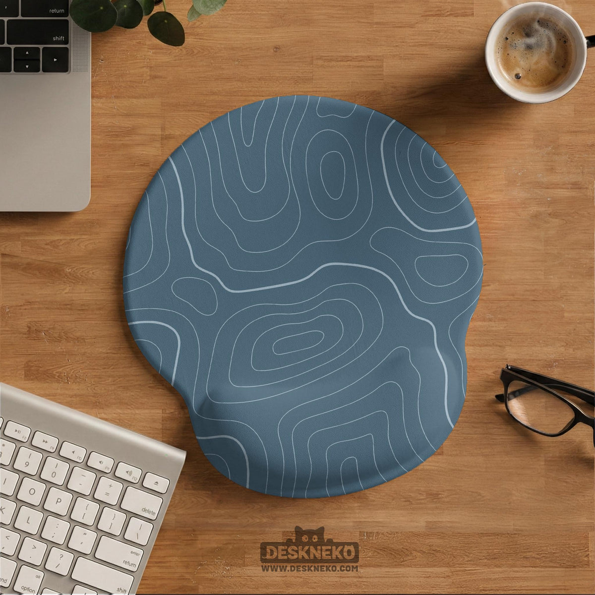 Muted blue desk mat with thin topographic line art pattern shown with matching mousepad and keyboard wrist rest options.