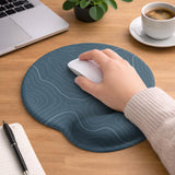 Muted blue desk mat with thin topographic line art pattern shown with matching mousepad and keyboard wrist rest options.