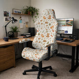 A gaming chair cover with a woodland animal print featuring foxes, rabbits, bears, mushrooms, and leaves in green, brown, and beige tones.