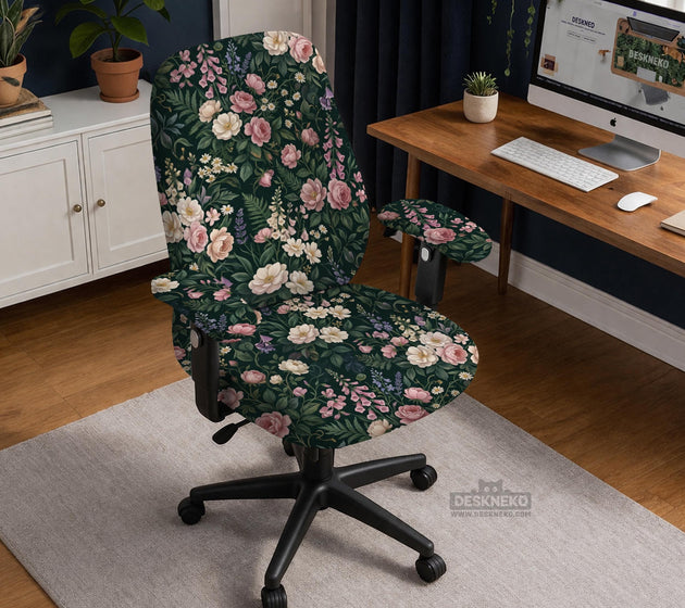 Green chair cover with a dark floral pattern, pink roses, cream flowers, and leafy botanical details on an office chair.