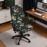 Green chair cover with a dark floral pattern, pink roses, cream flowers, and leafy botanical details on an office chair.