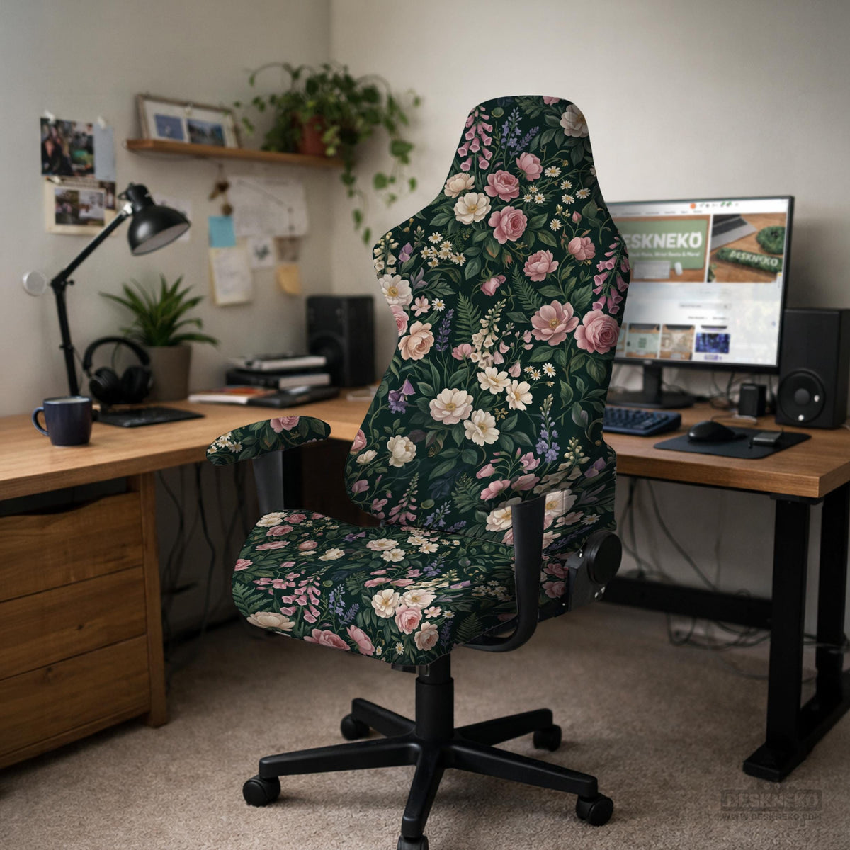 Green chair cover with a dark floral pattern, pink roses, cream flowers, and leafy botanical details on an office chair.
