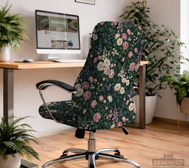 Green chair cover with a dark floral pattern, pink roses, cream flowers, and leafy botanical details on an office chair.