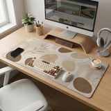 Beige desk mat with fine botanical line drawings and soft abstract shapes on a light neutral background.
