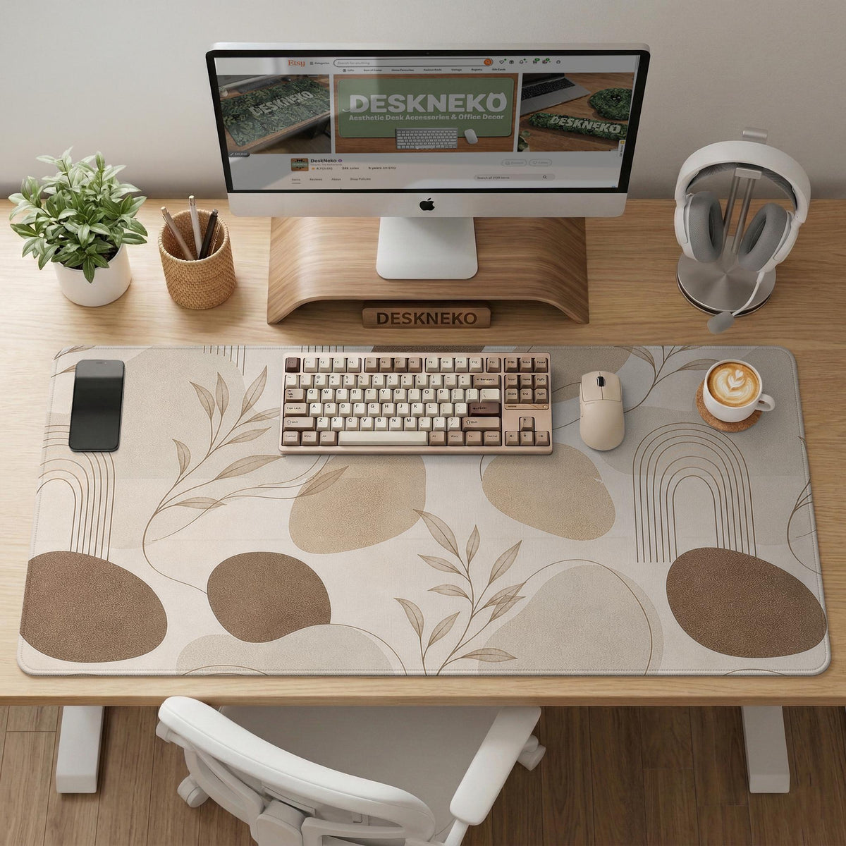Beige desk mat with fine botanical line drawings and soft abstract shapes on a light neutral background.