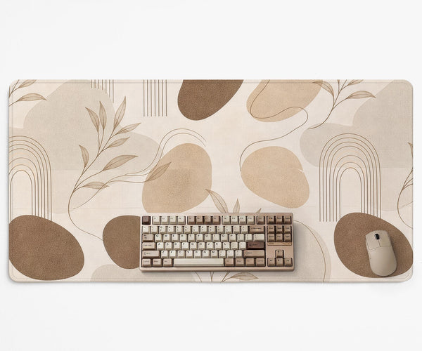 Beige desk mat with fine botanical line drawings and soft abstract shapes on a light neutral background.