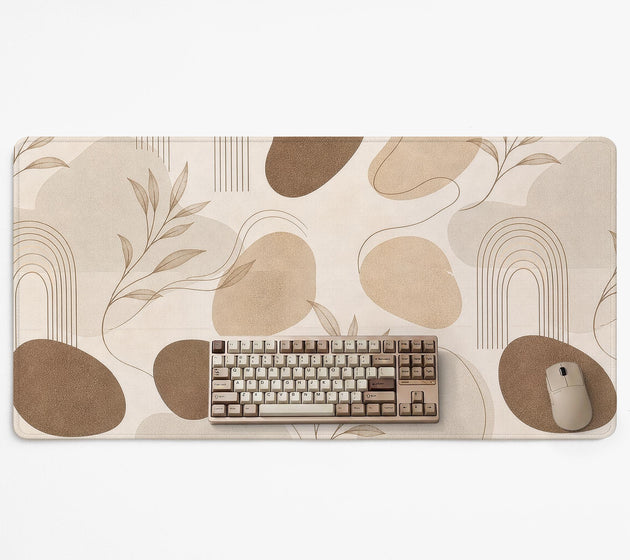 Beige desk mat with fine botanical line drawings and soft abstract shapes on a light neutral background.
