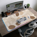 Beige desk mat with fine botanical line drawings and soft abstract shapes on a light neutral background.