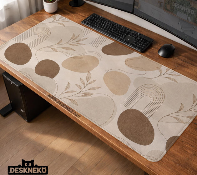 Beige desk mat with fine botanical line drawings and soft abstract shapes on a light neutral background.