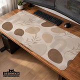 Beige desk mat with fine botanical line drawings and soft abstract shapes on a light neutral background.