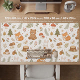 Cream desk mat with a woodland animal pattern featuring foxes, bunnies, mushrooms, berries, acorns, and sage leaves in soft green tones.