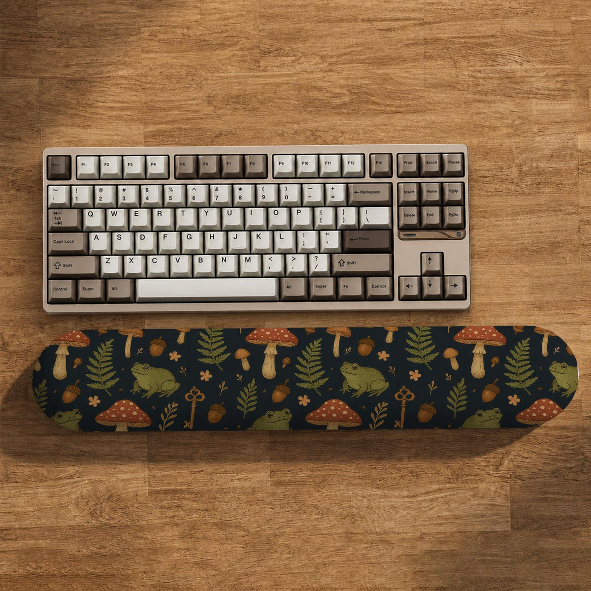 Dark botanical desk mat options with frogs, mushrooms, ferns, and acorns in brown and green tones, plus a matching keyboard wrist rest.