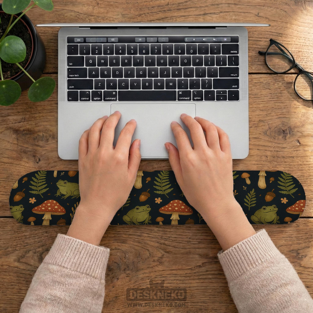 Dark botanical desk mat options with frogs, mushrooms, ferns, and acorns in brown and green tones, plus a matching keyboard wrist rest.