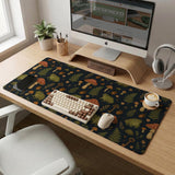 Dark forest-themed desk mat with an all-over pattern of frogs, mushrooms, fern leaves, acorns, tiny flowers, and antique keys.