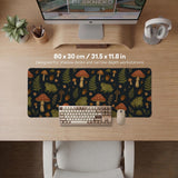 Dark forest-themed desk mat with an all-over pattern of frogs, mushrooms, fern leaves, acorns, tiny flowers, and antique keys.