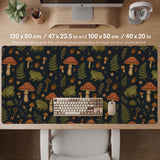 Dark forest-themed desk mat with an all-over pattern of frogs, mushrooms, fern leaves, acorns, tiny flowers, and antique keys.