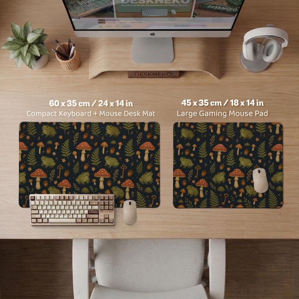 Dark forest-themed desk mat with an all-over pattern of frogs, mushrooms, fern leaves, acorns, tiny flowers, and antique keys.