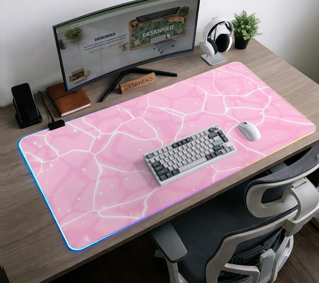 Pastel pink desk mat with a marble-style design, white flowing lines, and small sparkle accents.