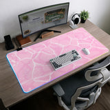 Pastel pink desk mat with a marble-style design, white flowing lines, and small sparkle accents.