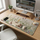 A desk mat with a botanical meadow design featuring wildflowers, leafy stems, and soft neutral colors.