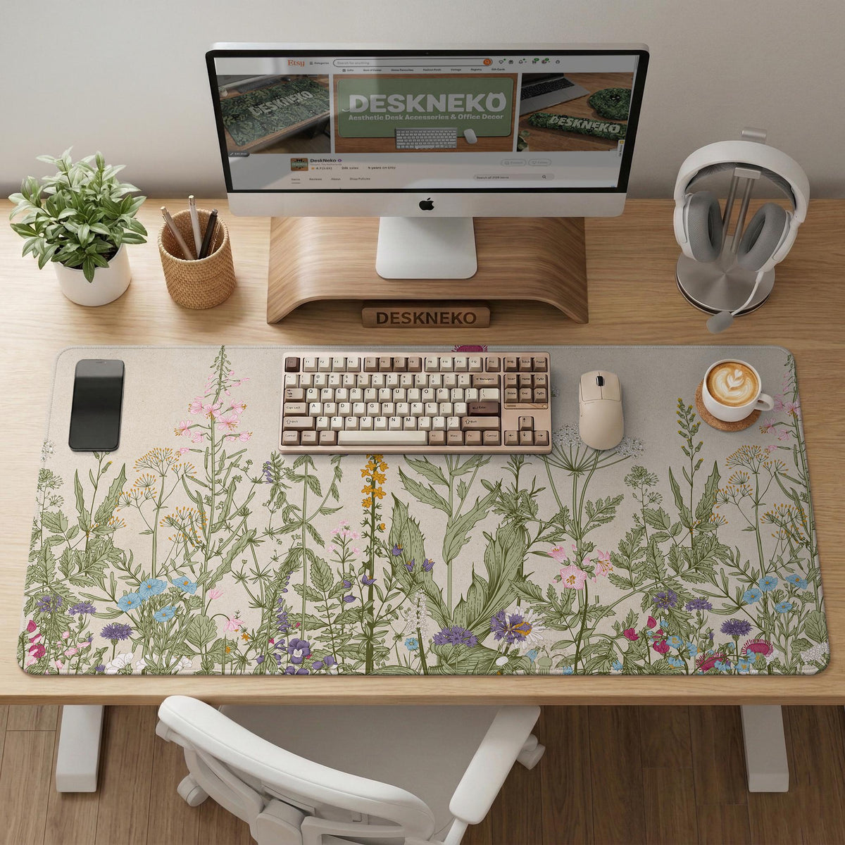 A desk mat with a botanical meadow design featuring wildflowers, leafy stems, and soft neutral colors.