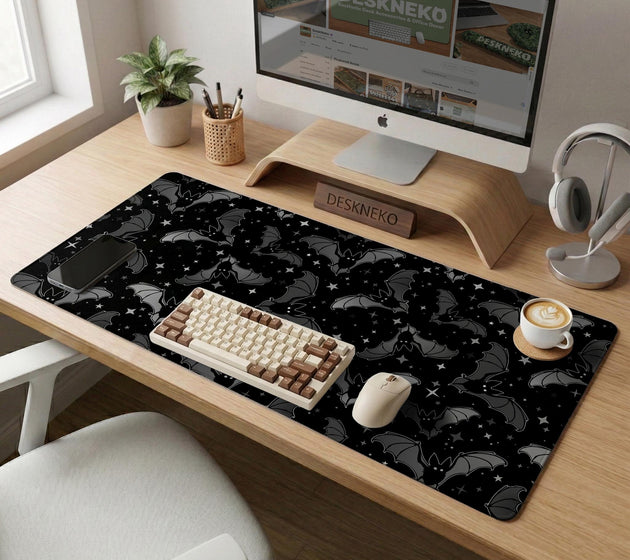 Black desk mat with a dark bat pattern and scattered stars on a charcoal background.