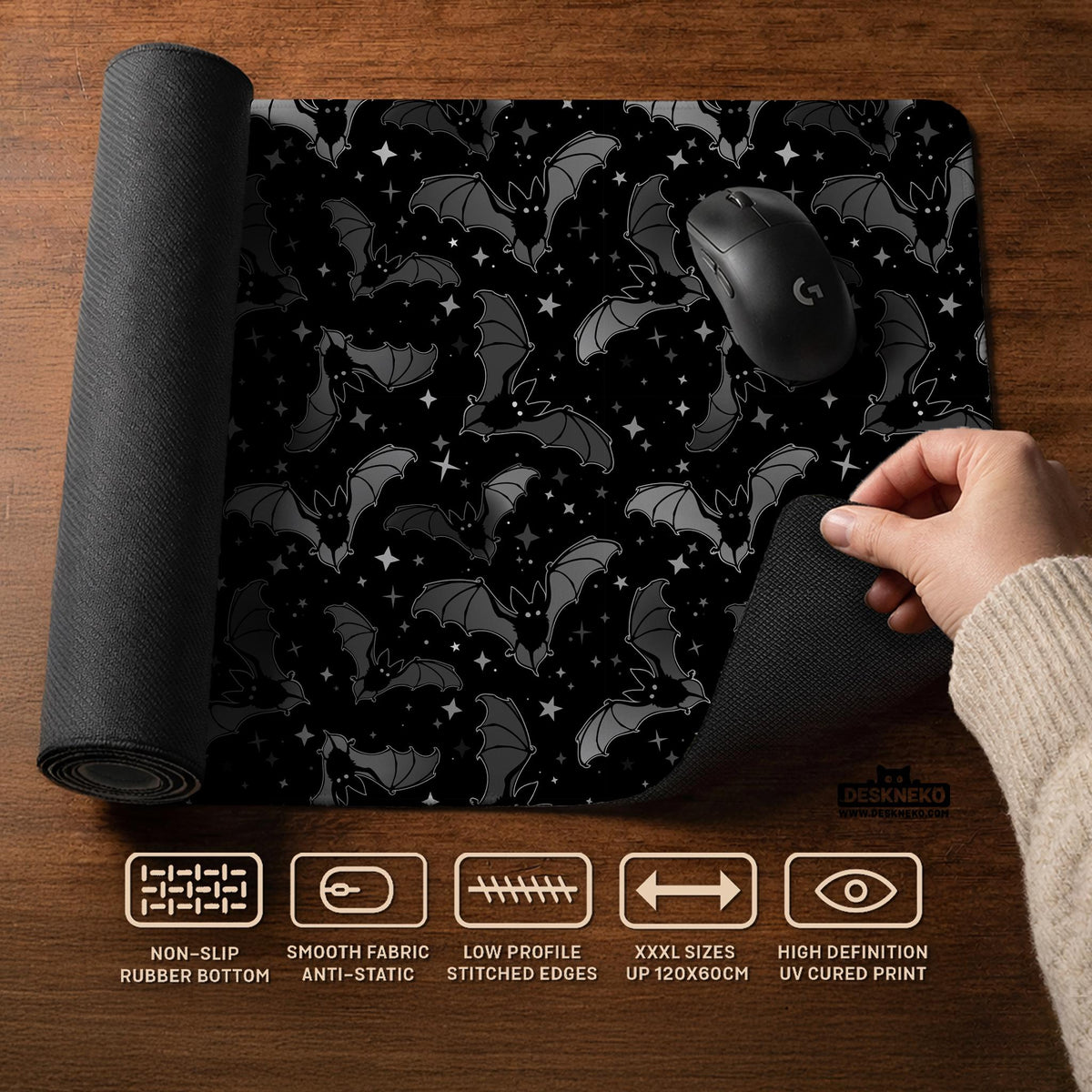 Black desk mat with a dark bat pattern and scattered stars on a charcoal background.
