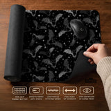 Black desk mat with a dark bat pattern and scattered stars on a charcoal background.
