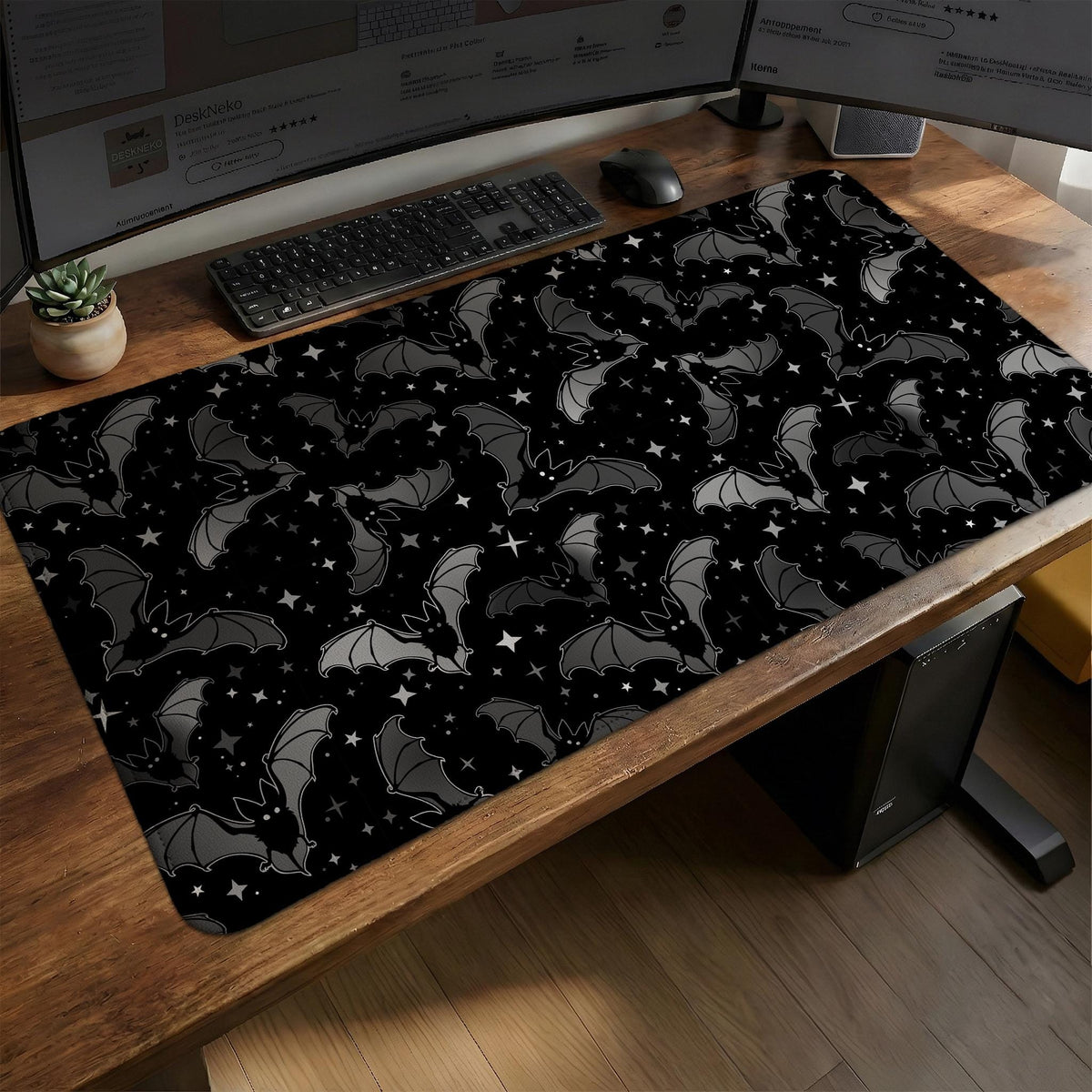 Black desk mat with a dark bat pattern and scattered stars on a charcoal background.